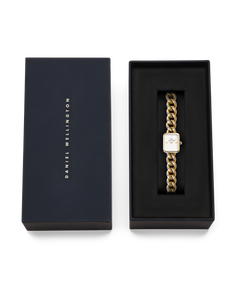 ダークネイビーのブランドボックスに収められたJolie Chain Goldのギフトパッケージです。蓋にはDaniel Wellingtonのロゴがゴールドで刻印され、ブラックのクッショニングの上にゴールドチェーンのブレスレットウォッチが丁寧にセットされています。贈り物にぴったりの上質な仕上がりです。