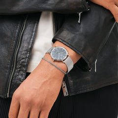 Classic Multi-Eye Sterling Onyxを着用したスタイリング例です。ブラックのレザージャケットの袖口から覗くシルバーメッシュのストラップと、オニキスブラックのダイヤルが、カジュアルな装いに洗練されたアクセントを添えています。