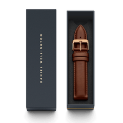 St Mawes XL ローズゴールドにブラウンレザーストラップを組み合わせ、ダークネイビーの専用ボックスに収めた状態です。ボックスの蓋にはDaniel Wellingtonのロゴがゴールドであしらわれており、ギフトにも最適な上品なパッケージとなっています。