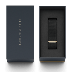 Daniel Wellington Cornwall Strap ローズゴールドのパッケージ画像です。ネイビーのブランドロゴ入りボックスの蓋と、ブラックのNATOストラップが収められた内箱が並んでいます。ギフトにもぴったりな上品な梱包です。