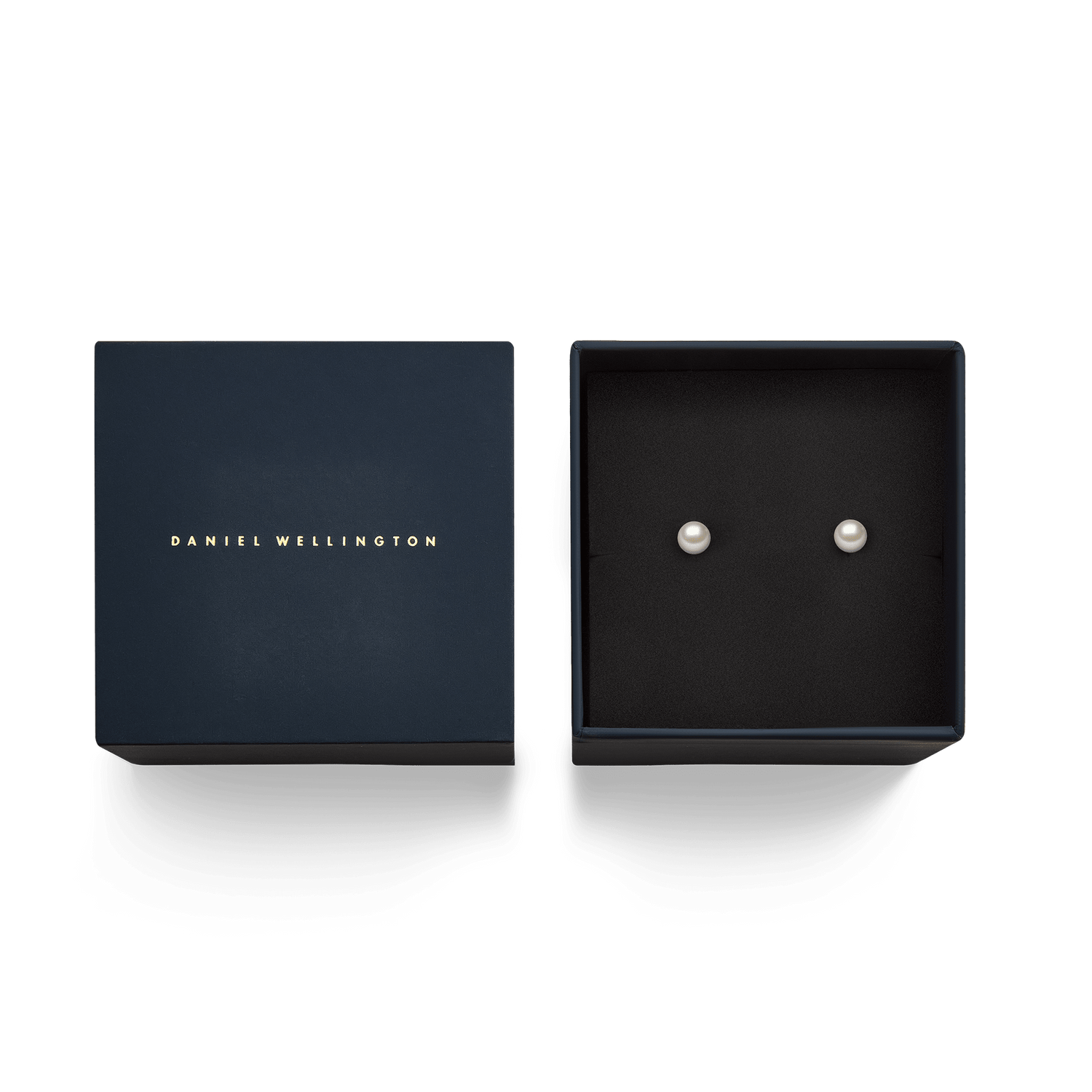 ダニエルウェリントンのギフトボックスに収められたパールスタッドピアス「Pearl Stud Earrings Gold」のパッケージ写真です。ネイビーブルーのボックス内にはブラックのクッションが敷かれ、ホワイトパールのスタッドピアスが並んでいます。贈り物にぴったりの上品な仕上がりです。