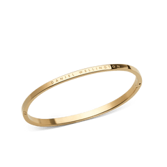 Classic Bangle Goldを斜めから捉えた製品画像です。サテン仕上げの表面とポリッシュ加工の上面にDaniel Wellingtonのロゴが刻印されており、ヒンジ部分の開閉構造もご確認いただけます。