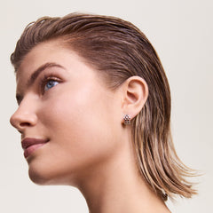 Daniel Wellingtonの5-Link Earringsシルバーを着用した女性の横顔。小ぶりな5連リンクのフープピアスが耳元で光を受け、洗練された印象を演出します。