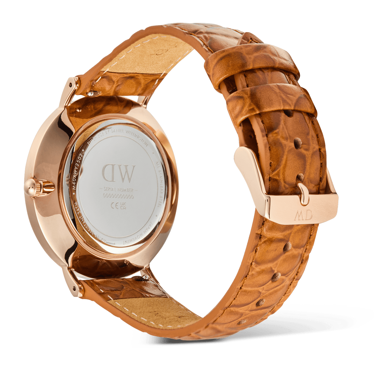Daniel Wellington Classic Roman Numerals Dateの裏面を捉えたアングルです。ローズゴールドケースの裏蓋にはブランドロゴやシリアルナンバーが刻印されており、ライトブラウンのクロコダイル調レザーストラップのローズゴールドピンバックルにはDWの刻印が施されています。