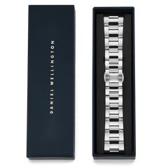 Smartwatch Iconic Linkシルバーのブレスレットが、ネイビーのDaniel Wellingtonブランドボックスに収められたパッケージ画像です。蓋にはゴールドのブランドロゴがあしらわれ、ギフトにもぴったりの上品な仕上がりとなっています。