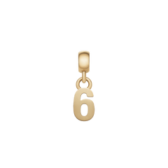 白背景に映えるDaniel WellingtonのNumber Charm Gold「6」。ゴールドメッキを施したステンレススチール素材が上品な光沢を放ち、上部のベイルと丸カンでつながるシンプルなデザインです。