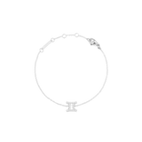 白背景で撮影した、ふたご座モチーフのCrystal Zodiac Chain Bracelet Silverです。繊細なシルバーチェーンがゆるやかな輪を描き、下部にはキュービックジルコニアであしらわれた双子座のシンボルチャームが配されています。チェーン上部にはアジャスターリングとロブスタークラスプ、ブランドプレートが付いています。