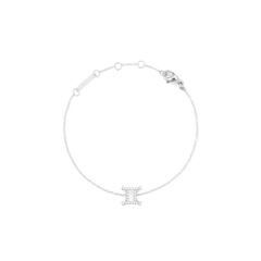 白背景で撮影した、ふたご座モチーフのCrystal Zodiac Chain Bracelet Silverです。繊細なシルバーチェーンがゆるやかな輪を描き、下部にはキュービックジルコニアであしらわれた双子座のシンボルチャームが配されています。チェーン上部にはアジャスターリングとロブスタークラスプ、ブランドプレートが付いています。
