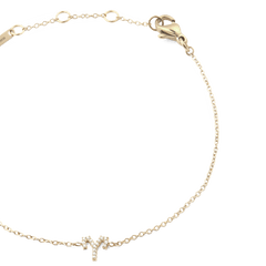 クリスタルZodiac Chain Bracelet Goldの牡羊座モデルをクローズアップで撮影した写真です。ゴールドチェーンにあしらわれたクリスタルの牡羊座モチーフや、ロブスタークラスプ、アジャスターリングの細部までご確認いただけます。