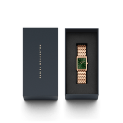 Daniel Wellingtonのネイビーのギフトボックスに収められたBound 9-Link Emerald Sunray。箔押しのブランドロゴが施された蓋と、黒いクッションの上にローズゴールドの9リンクブレスレットとエメラルドグリーンのダイヤルが映える本体が並んでいます。