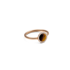 Daniel Wellington Audrey Ring Tiger Eye Rose Goldを斜めから捉えた画像です。琥珀色とブラウンの縞模様が美しいドーム型のタイガーアイと、周囲を彩るキュービックジルコニアの繊細な輝きが際立っています。