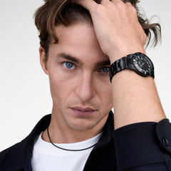 Daniel WellingtonのIconic Paradigma Link Blackを着用した男性モデル。ブラックのジャケットに、オールブラックの3リンクブレスレットが自然になじみ、手首元に上品なアクセントを添えています。