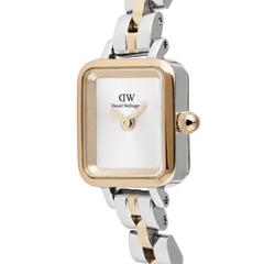 Quadro Mini Arch Two Tone Rose Goldを斜めから捉えたクローズアップ画像です。ローズゴールドのベゼルに縁取られた、インデックスのない白いサンレイダイヤルと、ローズゴールドの針が印象的。シルバーとローズゴールドのポリッシュ仕上げが美しい3リンクブレスレットの質感もご確認いただけます。
