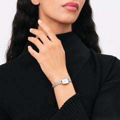 ブラックのハイネックニットに合わせたDaniel Wellington Quadro Mini Sterlingの着用シーンです。シルバーメッシュのストラップとコンパクトなスクエアケースが、手首にジュエリーのように自然になじみます。