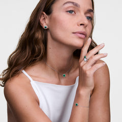 オードリー コレクションのマラカイトシルバージュエリーを身に着けた女性モデル。薬指にはAudrey Ring Malachite Silverを、同シリーズのネックレス、ブレースレット、イヤリングと合わせ、グリーンのマラカイトとシルバーのトーンを統一したスタイリングです。