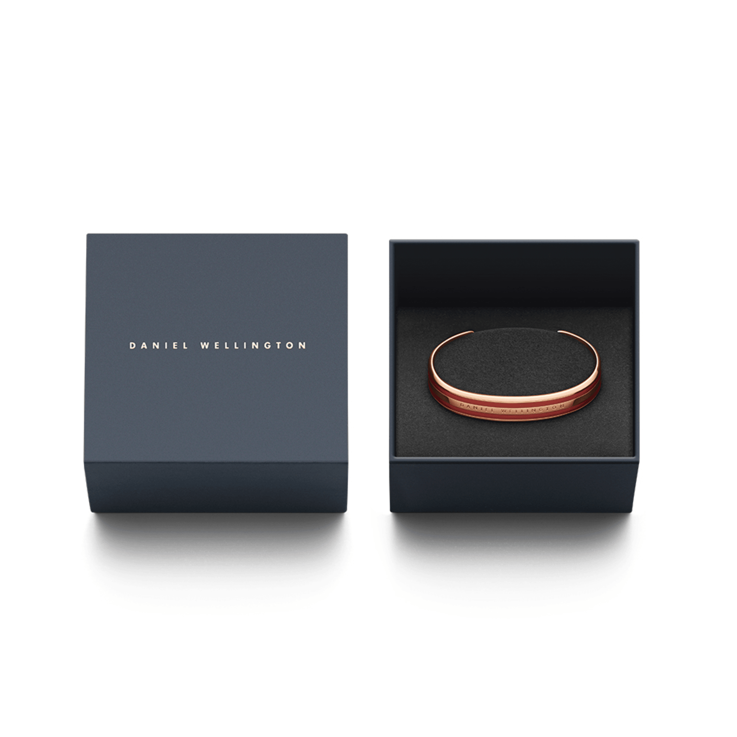 Emalie Bracelet Cherry Blush Rose Goldがダークネイビーのギフトボックスに収められた様子です。ブランドロゴ入りの蓋が左側に置かれ、右側の箱の中にはチェリーブラッシュエナメルとローズゴールドのカフブレスレットが黒いクッションカバーの上に丁寧にセットされています。