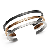 Daniel Wellington Classic Braceletのブラック、ローズゴールド、シルバー3色セットです。ブランドロゴが刻印されたミニマルなオープンカフデザインで、重ね付けしてお使いいただけます。