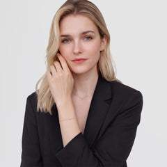 黒のジャケットを着た女性が、一粒ストーンのシルバーチェーンブレスレット、スタッドピアス、ネックレスを合わせたDaniel Wellingtonのジュエリーコーディネートです。