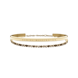 ダニエルウェリントンのClassic BraceletとTennis Bracelet Honeyのゴールドコンビセット。ブランド名が刻印されたゴールドカフと、ハニーカラーのクリスタルが連なるテニスブレスレットを重ねた正面からの商品画像です。