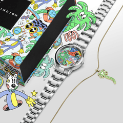 Steven Harrington x Daniel Wellington限定コラボセットの俯瞰画像です。カラフルなアートワークが施された専用パッケージの上に、マルチカラーダイヤルのIconic Linkシルバーウォッチと、ゴールドチェーンのパームツリーチャームネックレスが並んでいます。