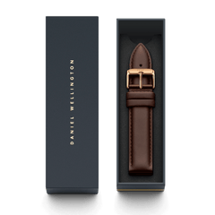 Bristol Strap ローズゴールドがダークネイビーの専用ギフトボックスに収められた画像です。ボックスの蓋にはDaniel Wellingtonのロゴがゴールドで印字されており、ダークブラウンのレザーストラップとローズゴールドのバックルが、贈り物にぴったりの上品なパッケージでお届けします。