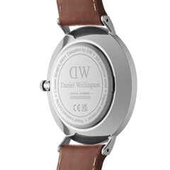 Classic Multi-Eye St Mawes Arctic Silverの裏蓋を写した画像です。シルバーのステンレススチールケースバックにはDaniel Wellingtonのロゴとシリアルナンバーが刻印されており、ブラウンレザーストラップのラグ部分やリューズの仕上げもご覧いただけます。