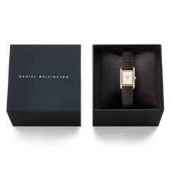 ダークネイビーのDaniel Wellington専用ギフトボックスに収められたBound Mini Black Lizard Rose Gold。クッションに包まれたローズゴールドケースとブラックリザード型押しのストラップが、ボックスの内装と美しく調和しています。