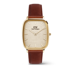 Daniel WellingtonのMarlon St Mawes Linen Goldを正面から撮影した画像です。丸みを帯びたクッションケースにゴールドの仕上げを施し、リネン織りのテクスチャーが特徴的なダイヤルとブラウンのレザーストラップを組み合わせた、ヴィンテージ感あふれる腕時計です。