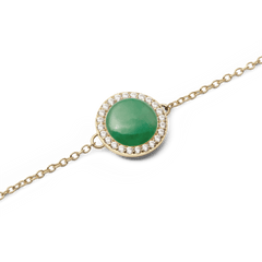 Audrey Bracelet Jade Goldの翡翠チャーム部分をクローズアップした画像です。ドーム型にカットされた天然翡翠の深いグリーンが美しく、その周囲をホワイトキュービックジルコニアのヘイローセッティングが彩ります。繊細なゴールドチェーンのディテールもご確認いただけます。