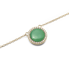 Audrey Necklace Jade Goldのペンダント部分をクローズアップした写真です。ドーム型の翡翠が光を受けてやわらかな緑色に輝き、周囲を彩るホワイトキュービックジルコニアの繊細なきらめきとゴールドフレームの上質な質感が際立ちます。