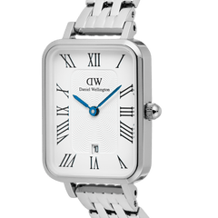 Daniel Wellington Quadro Roman Numerals Date 5-link Silverの文字盤をクローズアップした画像です。ギョーシェ模様の繊細な陰影やIPブルーの針、立体感のあるローマ数字インデックス、リューズの細部まで確認できます。シルバーケースのポリッシュ仕上げが光を反射し、美しい輝きを放っています。