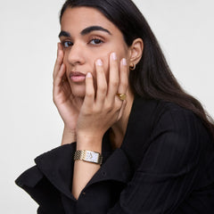 ダニエルウェリントン Classic Signet Ring Goldを着用したモデルの手元。黒のニットトップスに合わせ、ゴールドのシグネットリングとQuadroウォッチ、ゴールドのピアスでコーディネートしたスタイリングです。