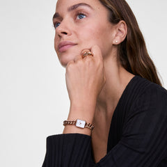 ダークトップスを着用した女性が、Jolie Chain Rose Goldを手首に合わせた着用イメージです。ローズゴールドのチェーンブレスレットウォッチが肌に馴染み、同系色のリングやピアスと合わせることで、ジュエリー感覚のスタイリングを楽しめます。
