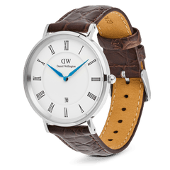 ダニエルウェリントン Classic Roman Numerals Date Dark Brown Croc Belly Silverを斜め横から捉えた画像です。ストラップ裏面のナチュラルレザーやステッチの仕上げ、リューズの細部まで確認できます。ホワイト文字盤にブルーの針が鮮やかに映えるデザインです。