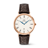 Daniel Wellington Classic Roman Numerals Dateの正面画像。ローズゴールドのケースにホワイト文字盤、ローマ数字のインデックス、ブルーの時分針、6時位置の日付表示窓を備え、ダークブラウンのクロコダイル風レザーストラップを合わせたデザインです。