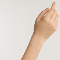 Daniel WellingtonのFlat Chain Bracelet Sを手首に着用した様子です。シルバーカラーのフラットチェーンが肌に馴染み、控えめな輝きで手元を引き立てます。細身のシルエットが、さりげないアクセントを添えています。