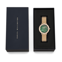 ダニエルウェリントンのブランドロゴがあしらわれたネイビーカラーのギフトボックスに収められたCrystalline Bezel Evergold Green。ブラックのクッショニング上に、ゴールドメッシュストラップとグリーンのマザーオブパールダイヤルが美しく映え、贈り物にぴったりの上質なパッケージです。
