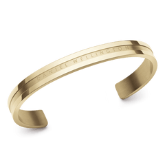 Daniel WellingtonのElan Braceletを斜めから捉えた画像です。ゴールドPVDメッキのカフブレスレットで、中央のサテン仕上げと両サイドのポリッシュ仕上げのコントラストが美しいディテールをご覧いただけます。