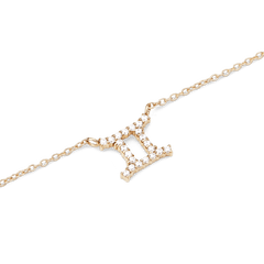 双子座のシンボルをクリスタルで表現したCrystal Zodiac Chain Necklace Goldのペンダント部分をクローズアップした写真です。ゴールドの爪留めにセットされたクリスタルが光を反射して輝き、細身のチェーンとの繊細なバランスが際立つ一枚です。