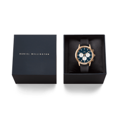 ダニエルウェリントンのネイビーカラーギフトボックスに収められたIconic Chronograph Sheffield Arctic Panda Rose Goldの画像です。箔押しのブランドロゴが施された蓋と、クッション上に丁寧にセットされた本体が並び、贈り物にぴったりの上質なパッケージをご覧いただけます。