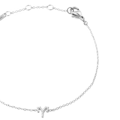 おひつじ座をモチーフにしたCrystal Zodiac Chain Bracelet Silverを斜めからクローズアップで撮影した画像です。キュービックジルコニアで描かれた牡羊座のシンボルチャームや、シルバーチェーンの繊細なリンク、ロブスタークラスプの質感など、細部まで美しく表現されています。