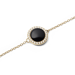 Audrey Bracelet Black Agathe Goldのチャーム部分をクローズアップした写真です。ドーム型にカットされた黒メノウのなめらかな曲面に光が映り、周囲を彩るホワイトキュービックジルコニアが繊細な輝きを放ちます。細身のゴールドチェーンとの調和が美しいディテールです。