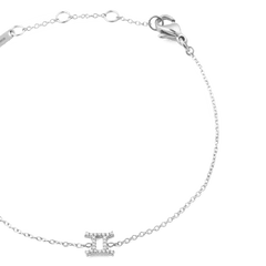 シルバーのCrystal Zodiac Chain Braceletふたご座モデルを斜め上から撮影した画像です。キュービックジルコニアがあしらわれたふたご座チャームとシルバーチェーンの質感がわかり、ロブスタークラスプやアジャスターリング、ブランドプレートも確認できます。