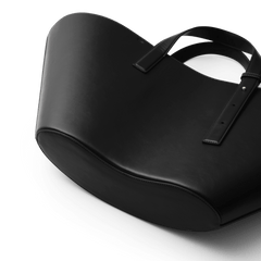 River Bag Blackの底部から見上げたアングルの画像です。丸みを帯びたボトムラインの美しいカーブと、滑らかなブラックレザーの質感、丁寧に仕上げられたステッチのディテールがわかります。