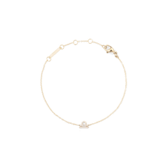 白背景に、天秤座モデルのCrystal Zodiac Chain Bracelet Goldを円を描くように配置した俯瞰画像です。ゴールドチェーンの中央下部には、クリスタルであしらわれた天秤座のシンボルが輝き、上部にはロブスタークラスプやアジャスターリング、ブランド刻印プレートが確認できます。