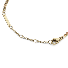 Classic Tennis Bracelet Apricot Goldのクラスプ部分のディテールです。Daniel Wellingtonの刻印が入ったゴールドのブランドプレートと、フラットに収まるロブスタークラスプ、サイズ調節用のチェーンが確認できます。