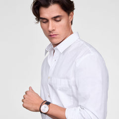 白シャツを着た男性がDaniel Wellington Classic Multi-Eye Sheffieldを着用した様子です。ローズゴールドのケースとブラックレザーのストラップが手首に自然になじみ、清潔感のあるスタイリングに上品なアクセントを添えています。