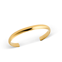 Arch Cuff Gold 6mmを斜めからとらえたクローズアップ画像です。光を受けて輝くポリッシュ仕上げのゴールドカラーと、内側に施された控えめな刻印が確認できます。