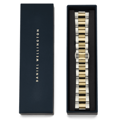 Daniel Wellingtonのネイビーのギフトボックスに収められたSmartwatch Iconic Linkツートンブレスレット。ボックスの蓋にはゴールドのブランドロゴがあしらわれ、内側にはシルバーとゴールドの3連リンクブレスレットが丁寧にセットされています。贈り物にぴったりの上品なパッケージです。