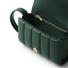 Mini Sadie Bag Greenのフラップを開いた内部をクローズアップした画像です。ゴールドジッパー付きの内ポケットやマグネットボタン、ブランドロゴの刻印が確認できます。また、縦のパフステッチが立体感のある陰影を生み出しています。